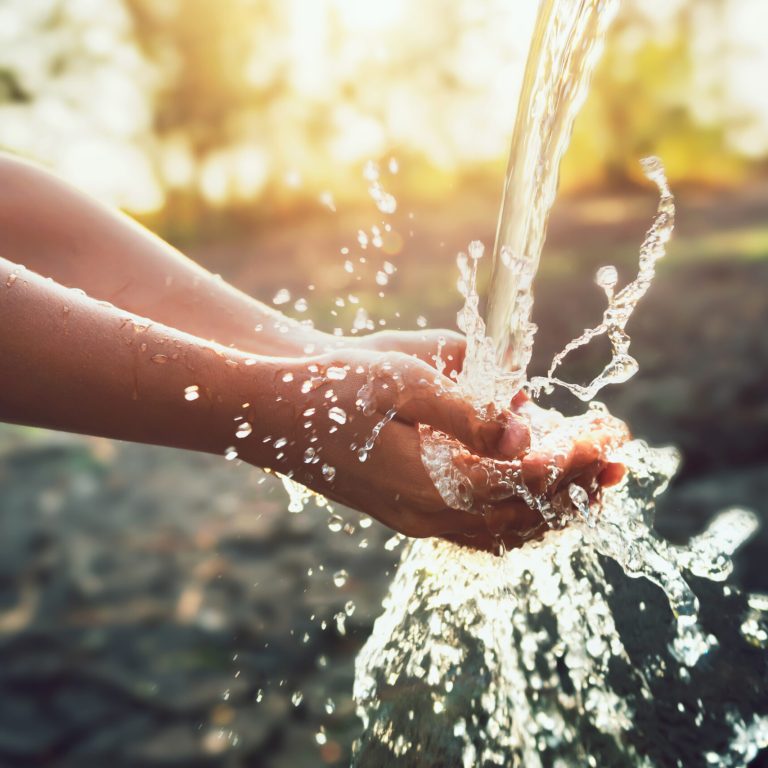 Water pouring on hand in morning ligth background